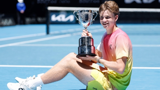 TOPSHOT - Switzerland's Henry Bernet poses with the winner's trophy after his victory against USA's Benjamin Willwerth in their junior boys' singles final match on day fourteen of the Australian Open tennis tournament in Melbourne on January 25, 2025. (Photo by Martin KEEP / AFP) / -- IMAGE RESTRICTED TO EDITORIAL USE - STRICTLY NO COMMERCIAL USE --