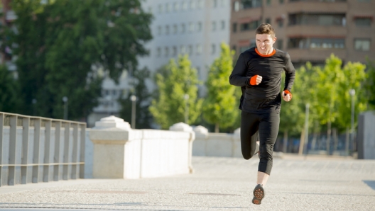 young athletic man practicing running on urban city park background in summer sport training session, body and health care and healthy lifestyle concept