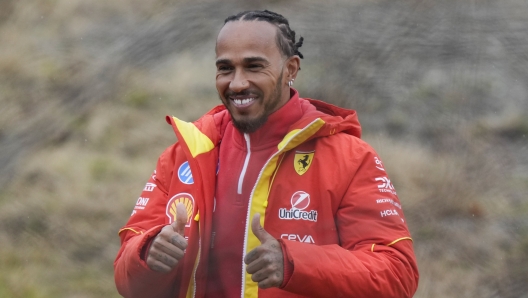 British driver Lewis Hamilton cheers Ferrari fans gathered outside the track, after testing a Ferrari Formula One SF-23, in Fiorano Modenese, Italy, Wednesday, Jan.22, 2025. (AP Photo/Luca Bruno)