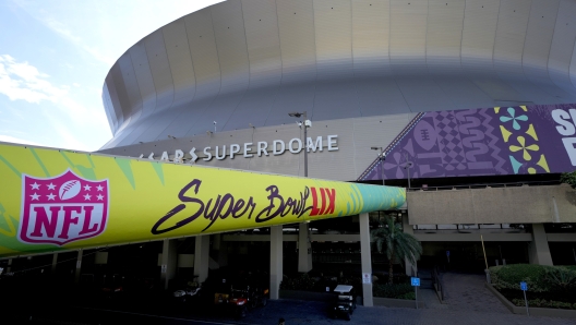 FILE - A lone security guard walks outside the Caesars Superdome, Jan. 31, 2025, in New Orleans ahead of the NFL Super Bowl 59 football game between the Philadelphia Eagles and the Kansas City Chiefs. (AP Photo/Matt York, File)