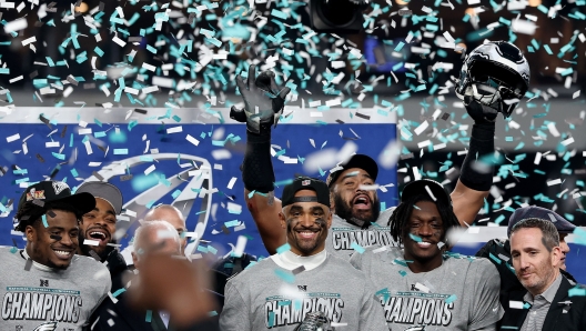 PHILADELPHIA, PENNSYLVANIA - JANUARY 26: Jalen Hurts #1 of the Philadelphia Eagles and teammates celebrate during the trophy ceremony after their 55-23 win against the Washington Commanders during the NFC Championship Game at Lincoln Financial Field on January 26, 2025 in Philadelphia, Pennsylvania.   Emilee Chinn/Getty Images/AFP (Photo by Emilee Chinn / GETTY IMAGES NORTH AMERICA / Getty Images via AFP)