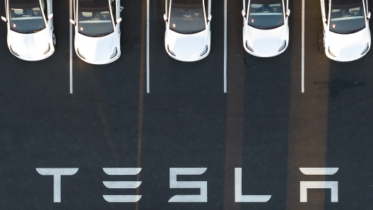 (FILES) An aerial view shows cars parked at the Tesla Fremont Factory in Fremont, California, on February 10, 2022. Tesla reported lower than expected profits on January 29, 2025, citing declining vehicle prices as a factor as it projected a return to volume growth in 2025. Elon Musk's electric car company reported fourth-quarter profits of $2.3 billion, which translated into 73 cents per share, four cents below analyst expectations. Revenues also lagged estimates. (Photo by JOSH EDELSON / AFP)