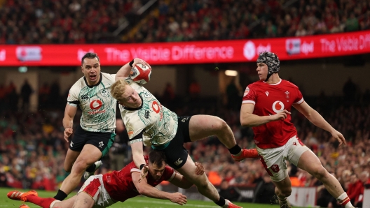 Ireland's full-back Jamie Osborne is tackled close to the try line during the Six Nations international rugby union match between Wales and Ireland at the Principality Stadium in Cardiff, south Wales, on February 22, 2025. (Photo by Adrian Dennis / AFP) / RESTRICTED TO EDITORIAL USE. Use in books subject to Welsh Rugby Union (WRU) approval.