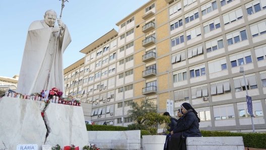 Nuns pray in front of the statue of late Pope John II outside the Agostino Gemelli Polyclinic where Pope Francis is battling pneumonia, in Rome, Saturday, Feb. 22, 2025,  (AP Photo/Gregorio Borgia)