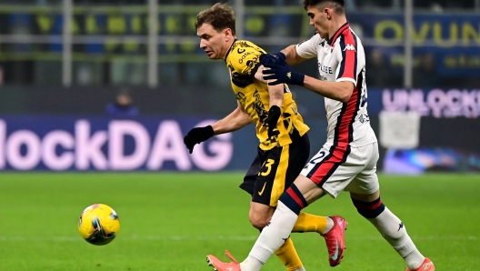 Inter Milan's Italian midfielder #23 Nicolo Barella (L) fights for the ball with Genoa?s Mexican defender #22 Johan Vsquez during the Italian Serie A football match between Inter Milan and Genoa at the San Siro Stadium in Milan on February 22, 2025. (Photo by Piero CRUCIATTI / AFP)