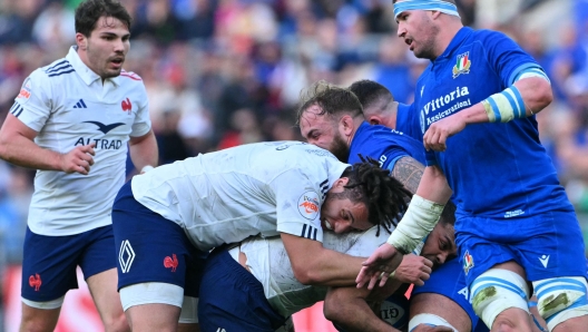 France's lock Mickael Guillard (2ndL) pushes France's hooker Peato Mauvaka who holds the ball, blocked by Italy's lock Niccolo Cannone during the Six Nations international rugby union match between Italy and France at the Stadio Olimpico, in Rome, on February 23, 2025. (Photo by Andreas SOLARO / AFP)