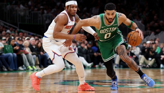 BOSTON, MASSACHUSETTS - FEBRUARY 23: Jayson Tatum #0 of the Boston Celtics drives to the basket against Miles McBride #2 of the New York Knicks during the second half at TD Garden on February 23, 2025 in Boston, Massachusetts. The Celtics defeat the Knicks 118-105. NOTE TO USER: User expressly acknowledges and agrees that, by downloading and or using this photograph, User is consenting to the terms and conditions of the Getty Images License Agreement.   Maddie Meyer/Getty Images/AFP (Photo by Maddie Meyer / GETTY IMAGES NORTH AMERICA / Getty Images via AFP)