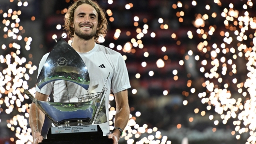 Greece's Stefanos Tsitsipas poses with the trophy on the podium after winning the final match of the ATP Dubai Duty Free Tennis Championship in Dubai on March 1, 2025. (Photo by Ryan Lim / AFP)