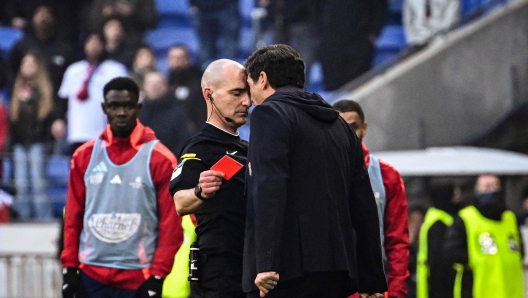 Lyon's Portuguese head coach Paulo Fonseca (R) yells at French referee Benoit Millot (L) after receiving a red card during the French L1 football match between Olympique Lyonnais (OL) and Stade Brestois 29 (Brest) at the Parc Olympique lyonnais in Decines-Charpieu, central-eastern France on March 2, 2025. (Photo by JEFF PACHOUD / AFP)