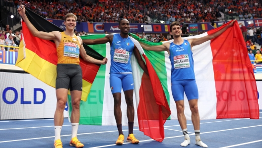 APELDOORN, NETHERLANDS - MARCH 08: (L-R) Silver medallist, Max Hess of Germany, gold medallist, Andy Diaz Hernandez of Italy and bronze medallist, Andrea Dallavalle of Italy, pose for a photo with national flags following the Men's Triple Jump Final in the European Athletics Indoor Championships at Omnisport Apeldoorn on March 08, 2025 in Apeldoorn, Netherlands. (Photo by Maja Hitij/Getty Images for European Athletics)