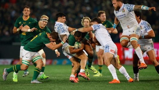 Italy's hooker Pablo Dimcheff (CR) tackles South Africa's fullback Damian Willemse (C) during the international rugby union Test match between South Africa and Italy at Loftus Versfeld stadium in Pretoria on July 5, 2025. (Photo by PHILL MAGAKOE / AFP)