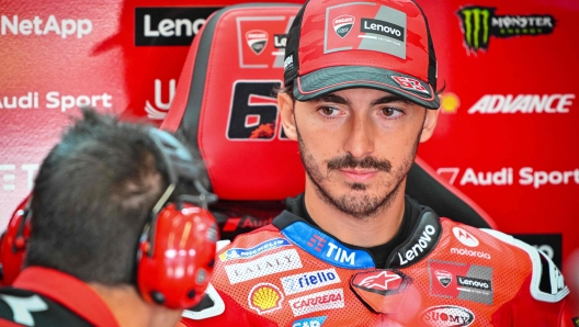Francesco Bagnaia speaking with an engineer in the Ducati pit garage.
