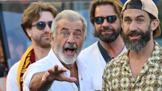TOPSHOT - US actor Mel Gibson (L) is pictured along the pitch before the Italian Serie A football match between AS Roma and Hellas Verona at the Olympic Stadium in Rome on September 28, 2025.
