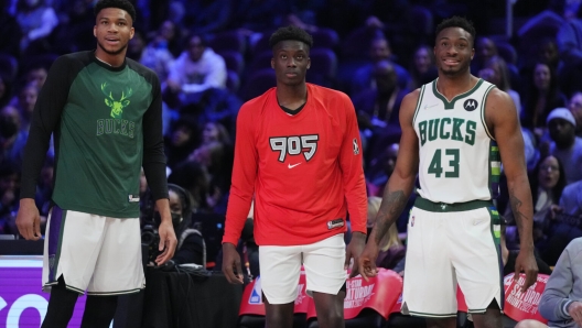 19 февраля 2022 года; Кливленд, Огайо, США; Игроки команды Адетокунбо Яннис Адетокунбо (34), Алекс Адетокунбо (29) и Танасис Адетокунбо (43) наблюдают за конкурсом мастерства во время Звездной субботней ночи НБА 2022 года на арене Rocket Mortgage Field House.