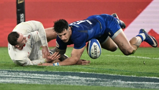 England's wing Tom Roebuck (L) scores a try next to Italy's centre Tommaso Menoncello during the Six Nations international rugby union match between Italy and England at the Stadio Olimpico in Rome, on March 7, 2026. (Photo by Tiziana FABI / AFP)