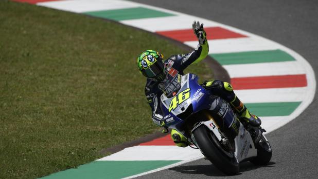 FILE - Italy's Valentino Rossi waves to fans prior to the start of the Italian Moto GP, at the Mugello race circuit, in Scarperia, Italy, on June 2, 2013. Record-breaking motorcycle racer. Charismatic showman. Italy's most popular athlete for years. Valentino Rossi was all that and more. He competed in his final race Sunday at the Valencia Grand Prix. He's the owner of nine world titles that include seven in the premier class. He's considered the greatest modern driver in his sport. (AP Photo/Gregorio Borgia, File)