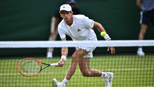 Italy's Matteo Arnaldi returns during his first round match at the Wimbledon qualifying tennis tournament in Roehampton in west London on June 26, 2023. Pristine grass courts and trademark white kit -- Wimbledon starts a week early for 256 veterans and young hopefuls battling it out in the qualifying tournament in leafy southwest London. The men's event began in Roehampton on Monday, with 128 players fighting for 16 slots in the main draw at the All England Club. (Photo by Ben Stansall / AFP) / RESTRICTED TO EDITORIAL USE