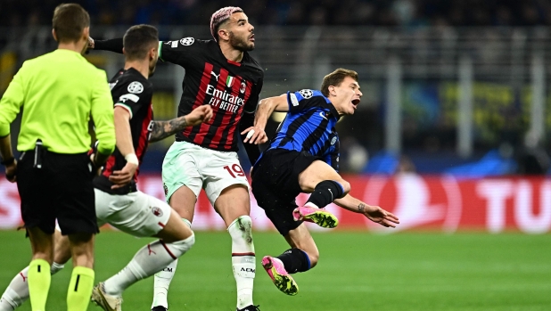 TOPSHOT - AC Milan's French defender Theo Hernandez (C) fouls Inter Milan's Italian midfielder Nicolo Barella during the UEFA Champions League semi-final second leg football match between Inter Milan and AC Milan on May 16, 2023 at tyhe Giuseppe-Meazza (San Siro) stadium in Milan. (Photo by GABRIEL BOUYS / AFP)
