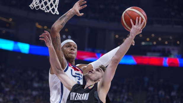 U.S. forward Paolo Banchero (8) goes up to block the3 shot of New Zealand guard Taylor Britt (4) during the first half of a Basketball World Cup group C match in Manila, Saturday, Aug. 26, 2023. (AP Photo/Michael Conroy)