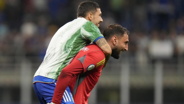 Italy goalkeeper Gianluigi Donnarumma, right, celebrates with Italy's Mattia Zaccagni at the end of the Euro 2024 group C qualifying soccer match between Italy and Ukraine at the San Siro stadium, in Milan, Italy, Tuesday, Sept.12, 2023. (AP Photo/Luca Bruno)