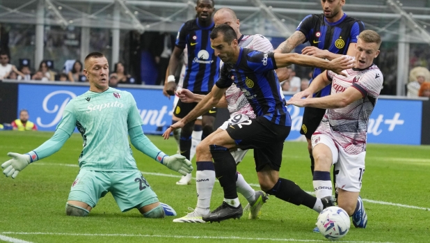 Inter Milan's Henrikh Mkhitaryan challenges for the ball with Bologna's Lewis Ferguson during a Serie A soccer match between Inter Milan and Bologna at the San Siro stadium in Milan, Italy, Saturday, Oct.7, 2023. (AP Photo/Luca Bruno)