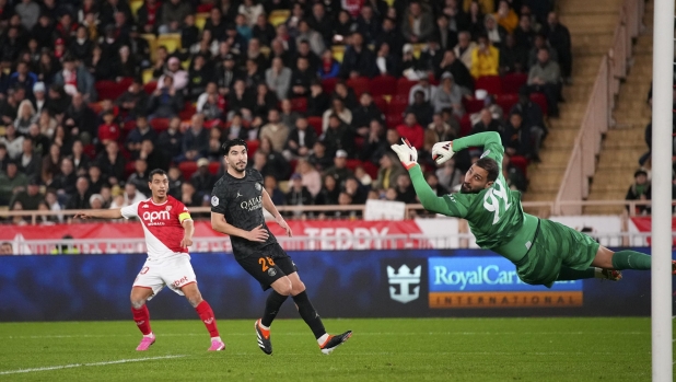 PSG's goalkeeper Gianluigi Donnarumma watches as shot from Monaco's Wissam Ben Yedder, left, goes over the bar during the French League One soccer match between Monaco and Paris Saint-Germain at the Stade Louis II in Monaco, Friday, March 1, 2024. (AP Photo/Daniel Cole)