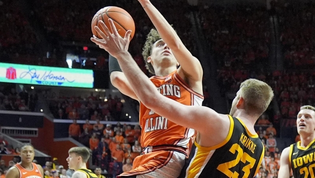 Illinois' Niccolo Moretti, right, shoots over Iowa's Ben Krikke during the second half of an NCAA college basketball game Saturday, Feb. 24, 2024, in Champaign, Ill. Illinois won 95-85. (AP Photo/Charles Rex Arbogast)