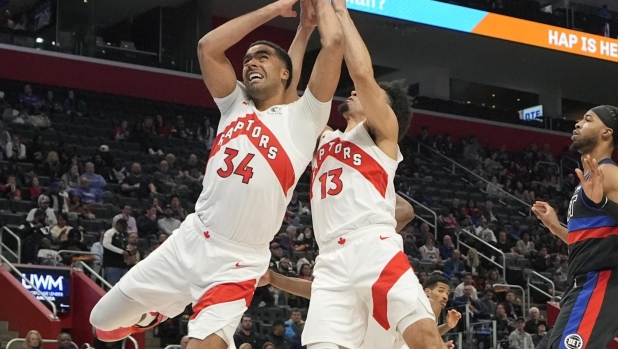 Toronto Raptors center Jontay Porter (34) and forward Jordan Nwora (13) reach for the rebound during the second half of an NBA basketball game against the Detroit Pistons, Wednesday, March 13, 2024, in Detroit. (AP Photo/Carlos Osorio)