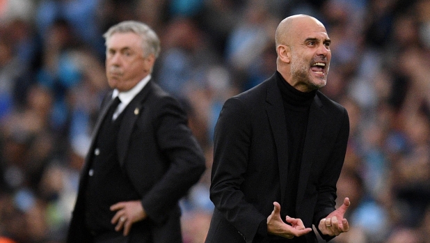 Manchester City's Spanish manager Pep Guardiola (R), watched by Real Madrid's Italian coach Carlo Ancelotti, celebrates the opening goal during the UEFA Champions League second leg semi-final football match between Manchester City and Real Madrid at the Etihad Stadium in Manchester, north west England, on May 17, 2023. (Photo by Oli SCARFF / AFP)