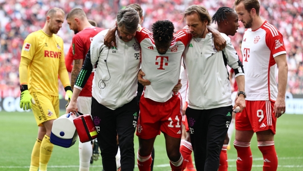epa11276542 Munich's Kingsley Coman receives medical treatment during the German Bundesliga soccer match between FC Bayern Munich and 1. FC Cologne in Munich, Germany, 13 April 2024.  EPA/ANNA SZILAGYI CONDITIONS - ATTENTION: The DFL regulations prohibit any use of photographs as image sequences and/or quasi-video.