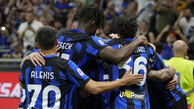 Inter Milan players celebrate after Hakan Calhanoglu scored his side's second goal during the Italian Serie A soccer match between Inter Milan and Cagliari at the San Siro stadium in Milan, Italy, Sunday, April 14, 2024. (AP Photo/Antonio Calanni)