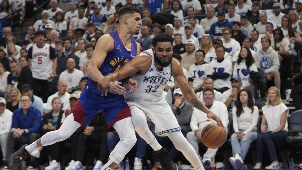 Minnesota Timberwolves center Karl-Anthony Towns (32) drives against s Denver Nuggets forward Michael Porter Jr. during the second half of Game 6 of an NBA basketball second-round playoff series Thursday, May 16, 2024, in Minneapolis. (AP Photo/Abbie Parr)