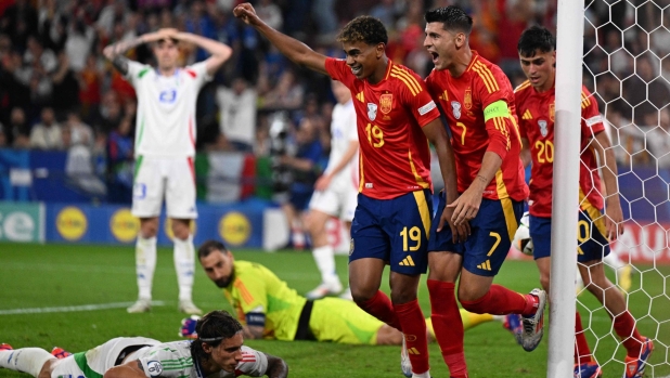 Spain's forward #19 Lamine Yamal (C) and Spain's forward #07 Alvaro Morata (centre right) celebrate as Italy's defender #05 Riccardo Calafiori (L) reacts after scoring an own goal during the UEFA Euro 2024 Group B football match between Spain and Italy at the Arena AufSchalke in Gelsenkirchen on June 20, 2024. (Photo by PATRICIA DE MELO MOREIRA / AFP)