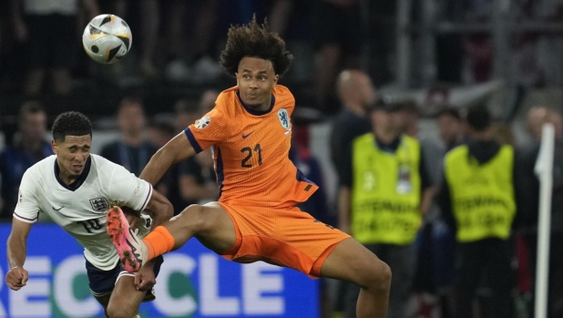 Netherlands's Joshua Zirkzee right, challenges England's Jude Bellingham during a semifinal match between the Netherlands and England at the Euro 2024 soccer tournament in Dortmund, Germany, Wednesday, July 10, 2024. (AP Photo/Darko Vojinovic)