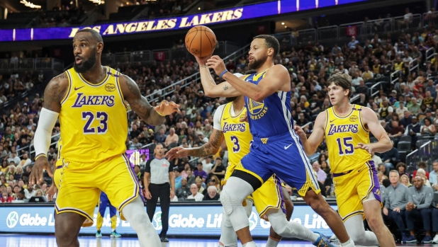 LAS VEGAS, NEVADA - OCTOBER 15: Stephen Curry #30 of the Golden State Warriors passes as LeBron James #23 of the Los Angeles Lakers defends in the first quarter of their preseason game at T-Mobile Arena at T-Mobile Arena on October 15, 2024 in Las Vegas, Nevada. The Warriors defeated the Lakers 111-97. NOTE TO USER: User expressly acknowledges and agrees that, by downloading and or using this photograph, User is consenting to the terms and conditions of the Getty Images License Agreement.   Ethan Miller/Getty Images/AFP (Photo by Ethan Miller / GETTY IMAGES NORTH AMERICA / Getty Images via AFP)