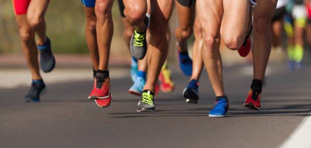 Marathon running race, people feet on city roa