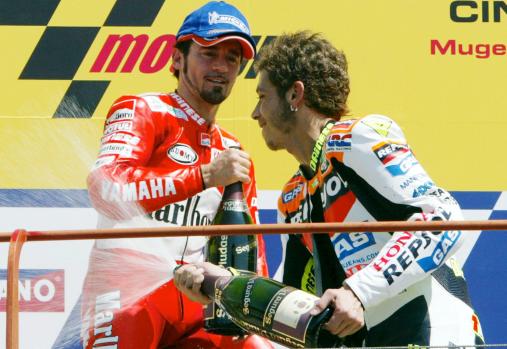 L'italiano Valentino Rossi, festeggia la sua vittoria nella categoria MotoGP, sul Podio, cercando di spruzzare di spumante a Max Biaggi. ANSA/CLAUDIO ONORATI