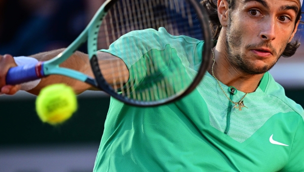 Italy's Lorenzo Musetti plays a backhand return to Britain's Cameron Norrie during their men's singles match on day six of the Roland-Garros Open tennis tournament at the Court Simonne-Mathieu in Paris on June 2, 2023. (Photo by Emmanuel DUNAND / AFP)