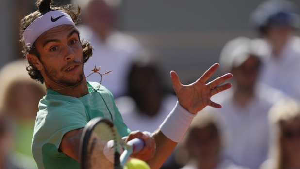 Italy's Lorenzo Musetti plays a shot against Spain's Carlos Alcaraz during their fourth round match of the French Open tennis tournament at the Roland Garros stadium in Paris, Sunday, June 4, 2023. (AP Photo/Thibault Camus)