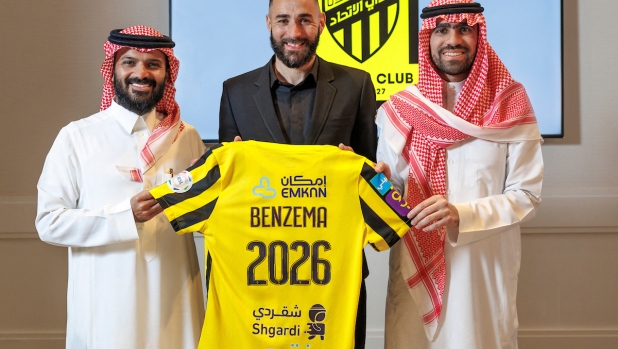 In this handout picture release by the Saudi Pro League on June 6, 2023, French football player Karim Benzema holds the jersey of Saudi Arabia's Al-Ittihad club as he poses for a picture flanked by Al-Ittihad members, in Madrid. Real Madrid's Ballon d'Or winner Karim Benzema will join Cristiano Ronaldo in Saudi Arabia after signing a three-year deal with Al-Ittihad, the Jeddah-based club confirmed on June 6. (Photo by jorge ferrari / Saudi Pro League / AFP)