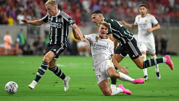 Manchester United's Dutch midfielder Donny van de Beek (L) and Manchester United's Portuguese defender Diogo Dalot (R) fight for the ball with Real Madrid's Argentine midfielder Nico Paz (C) during a pre-season friendly football match between Real Madrid CF and Manchester United FC at NRG Stadium in Houston, Texas, on July 26, 2023. (Photo by Mark Felix / AFP)