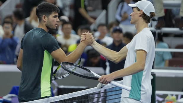 Jannik Sinner of Italy, right, shakes hands with Carlos Alcaraz of Spain after beating him in the men's singles semifinal match of the China Open tennis tournament at the Diamond Court in Beijing, Tuesday, Oct. 3, 2023. (AP Photo/Andy Wong)