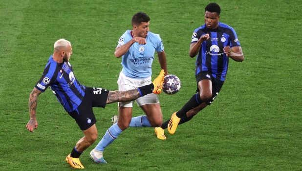 ISTANBUL, TURKEY - JUNE 10: Rodri of Manchester City is challenged by Federico Dimarco and Denzel Dumfries of FC Internazionale during the UEFA Champions League 2022/23 final match between FC Internazionale and Manchester City FC at Atatuerk Olympic Stadium on June 10, 2023 in Istanbul, Turkey. (Photo by Lars Baron/Getty Images)
