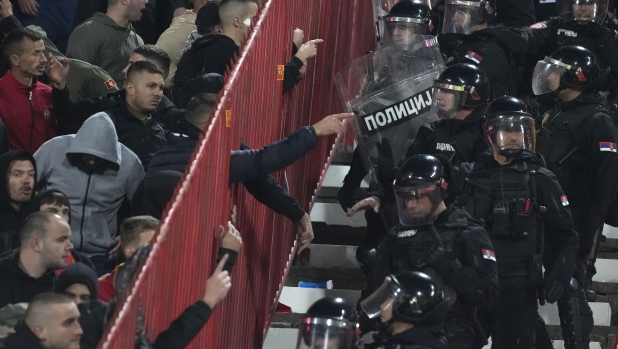 Riot policemen arrive to secure the area during the Euro 2024 group G qualifying soccer match between Serbia and Montenegro, at the Rajko Mitic Stadium in Belgrade, Serbia, Tuesday, Oct. 17, 2023. (AP Photo/Darko Vojinovic)