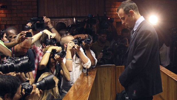 FILE - Photographers take pictures of Olympic athlete Oscar Pistorius as he appears at a bail hearing for the shooting death of his girlfriend Reeva Steenkamp, in Pretoria, South Africa, on Feb 22, 2013. Oscar Pistorius is due on Friday, Jan. 5, 2024 to be released from prison on parole to live under strict conditions at a family home after serving nearly nine years of his murder sentence for the shooting death of girlfriend Reeva Steenkamp on Valentine?s Day 2013. (AP Photo/Themba Hadebe, File)