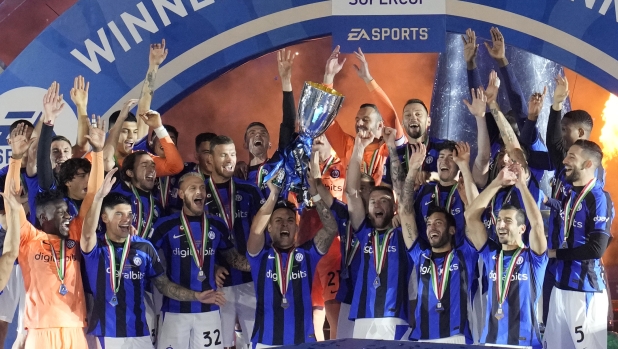 Inter Milan's Lautaro Martinez holds the trophy as he celebrates with his teammates after winning the Italian Super Cup final soccer match between AC Milan and Inter Milan at the King Saud University Stadium, in Riyadh, Saudi Arabia, Wednesday, Jan. 18, 2023. Inter Milan won 3-0. (AP Photo/Hussein Malla)