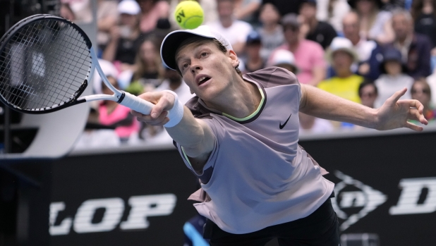 Jannik Sinner of Italy plays a backhand return to Sebastian Baez of Argentina during their third round match at the Australian Open tennis championships at Melbourne Park, Melbourne, Australia, Friday, Jan. 19, 2024. (AP Photo/Andy Wong)