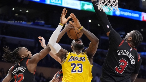 Los Angeles Lakers forward LeBron James, tries to shoot as Chicago Bulls guard Ayo Dosunmu, left, and center Andre Drummond defend during the second half of an NBA basketball game Thursday, Jan. 25, 2024, in Los Angeles. (AP Photo/Mark J. Terrill)