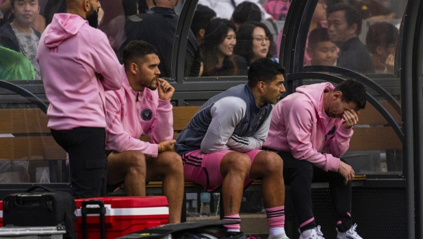 Inter Miami's Lionel Messi, right, reacts from the bench during the friendly football match between Hong Kong Team and US Inter Miami CF at the Hong Kong Stadium in Hong Kong, Sunday, Feb. 4, 2024. (AP Photo/Louise Delmotte)