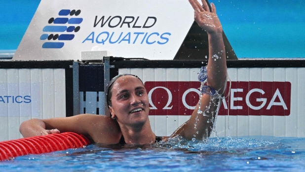 Italy's Simona Quadarella celebrates after winning the final of the women's 1500m freestyle swimming event during the 2024 World Aquatics Championships at Aspire Dome in Doha on February 13, 2024. (Photo by Oli SCARFF / AFP)